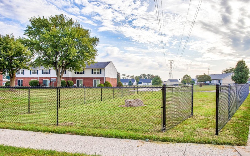 a fenced in area with a building in the background